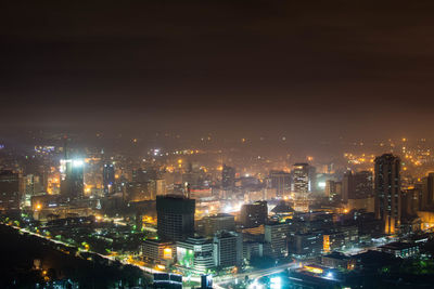 Illuminated cityscape against sky at night