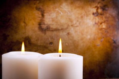 Close-up of lit candles on wall