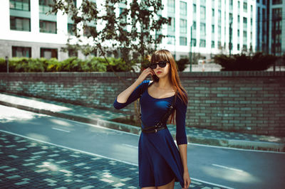 Young woman standing on street in city