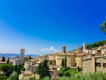 Buildings in city against clear blue sky