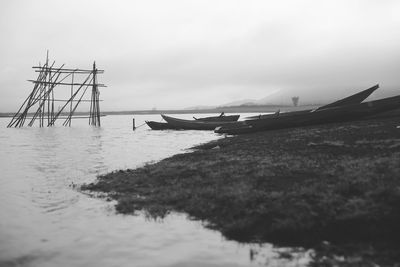 Sailboats moored on sea against sky