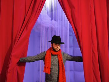 Portrait of man standing in red umbrella