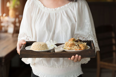 Midsection of woman holding ice cream in plate