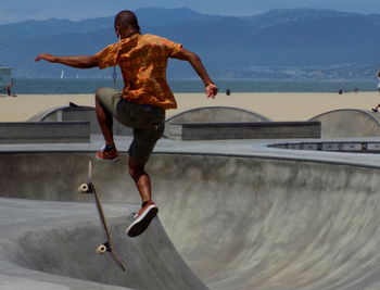 Full length of man skateboarding on skateboard against sky