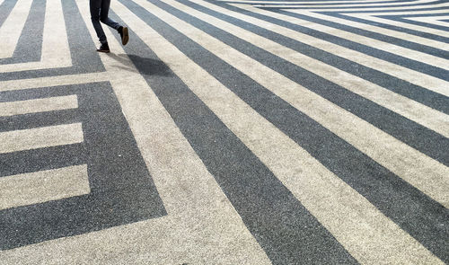 Low section of man walking on zebra crossing