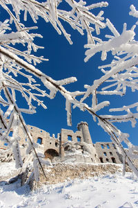 Snow covered land against blue sky