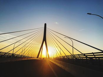 Bridge over road against sky during sunset