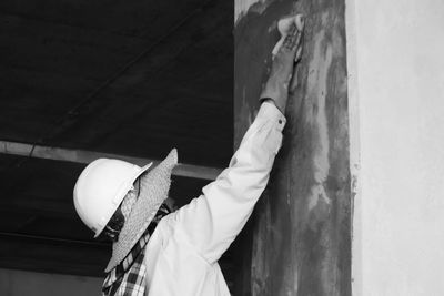 Rear view of person standing against wall