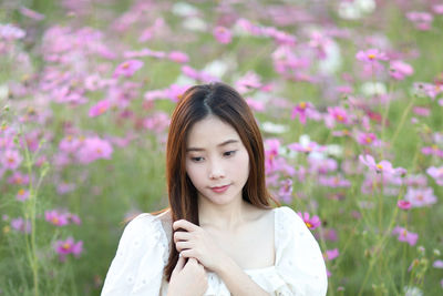 Portrait of young woman standing amidst plants