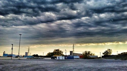 Cars on road against dramatic sky