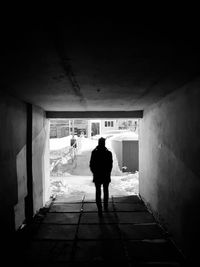 Rear view of silhouette man walking in building