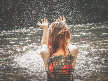 Rear view of woman standing in water