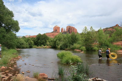 Rear view of man and woman crossing river at red rocks state park