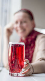 Woman having red juice at home