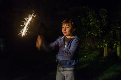 Boy holding sparkler at night