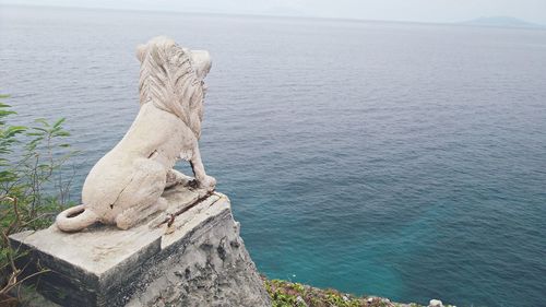 Lion statue against sea