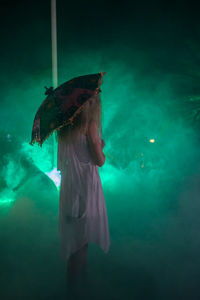 Woman standing in water at night