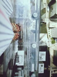 Low section of woman standing in balcony above buildings in city