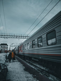 Train on railroad tracks against sky during winter