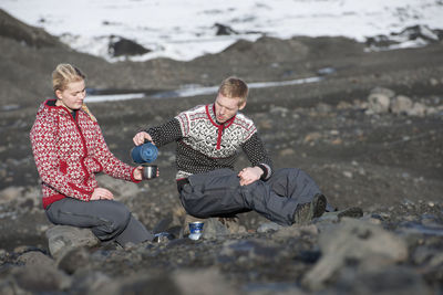 Young couple having a picnic in barren landscape in iceland