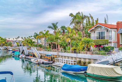 Boats moored in swimming pool by building against sky