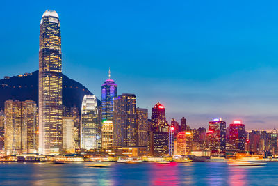 Illuminated buildings in city against sky