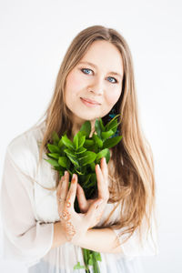 Portrait of a smiling young woman against white background