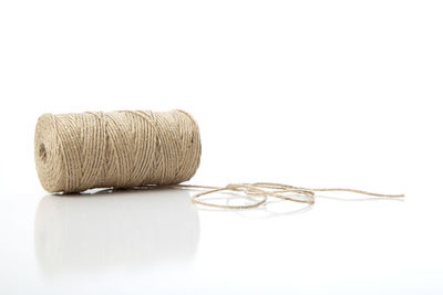 Close-up of wool spool over white background