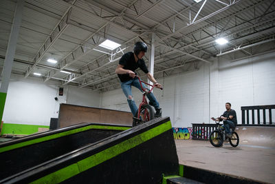 People riding bicycle in building