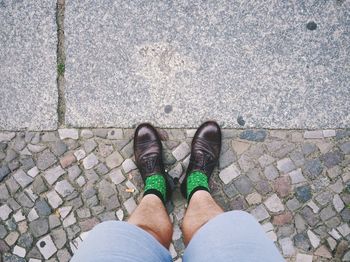 Low section of person standing on footpath