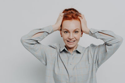 Portrait of smiling young woman against white background