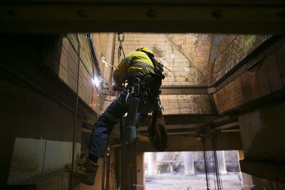 Low angle view of man working on building