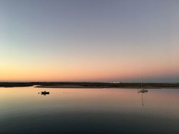 Scenic view of lake against clear sky during sunset