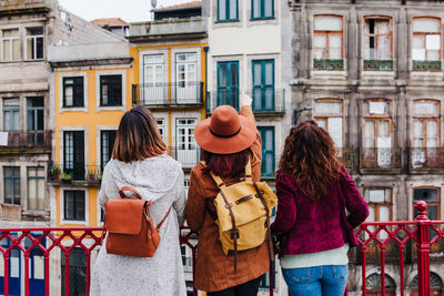 Rear view of women standing outside building