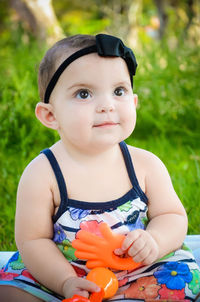 Portrait of cute girl sitting on field