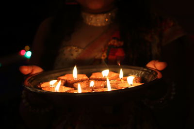 Close-up of lit candles in the dark