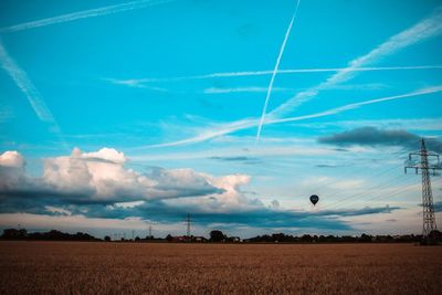 Scenic view of agricultural field against blue sky