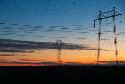 Electricity pylon against sky during sunset