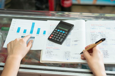 Top view of a girl's hand pointing to her business statistics chart. writing with an eco-friendly