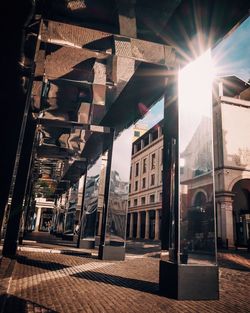 Sun shining through buildings in city