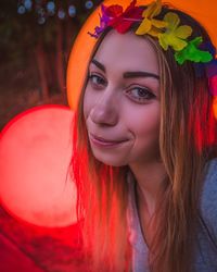 Close-up portrait of smiling woman wearing tiara against illuminated light