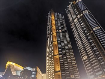 Low angle view of illuminated buildings against sky at night