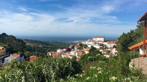 High angle view of townscape by sea against sky