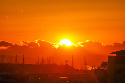 Silhouette buildings against romantic sky at sunset