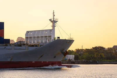 Sailboats moored on sea against clear sky during sunset