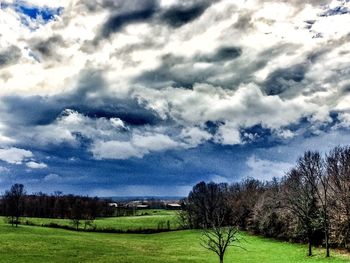 Scenic view of grassy field against cloudy sky