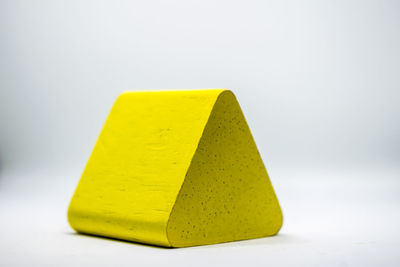 Close-up of yellow object over white background