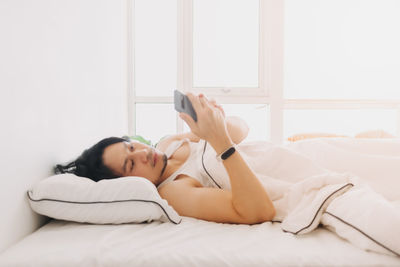 Young woman lying on bed at home