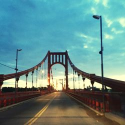 Bridge over river against cloudy sky