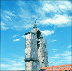 Low angle view of cross on building against sky